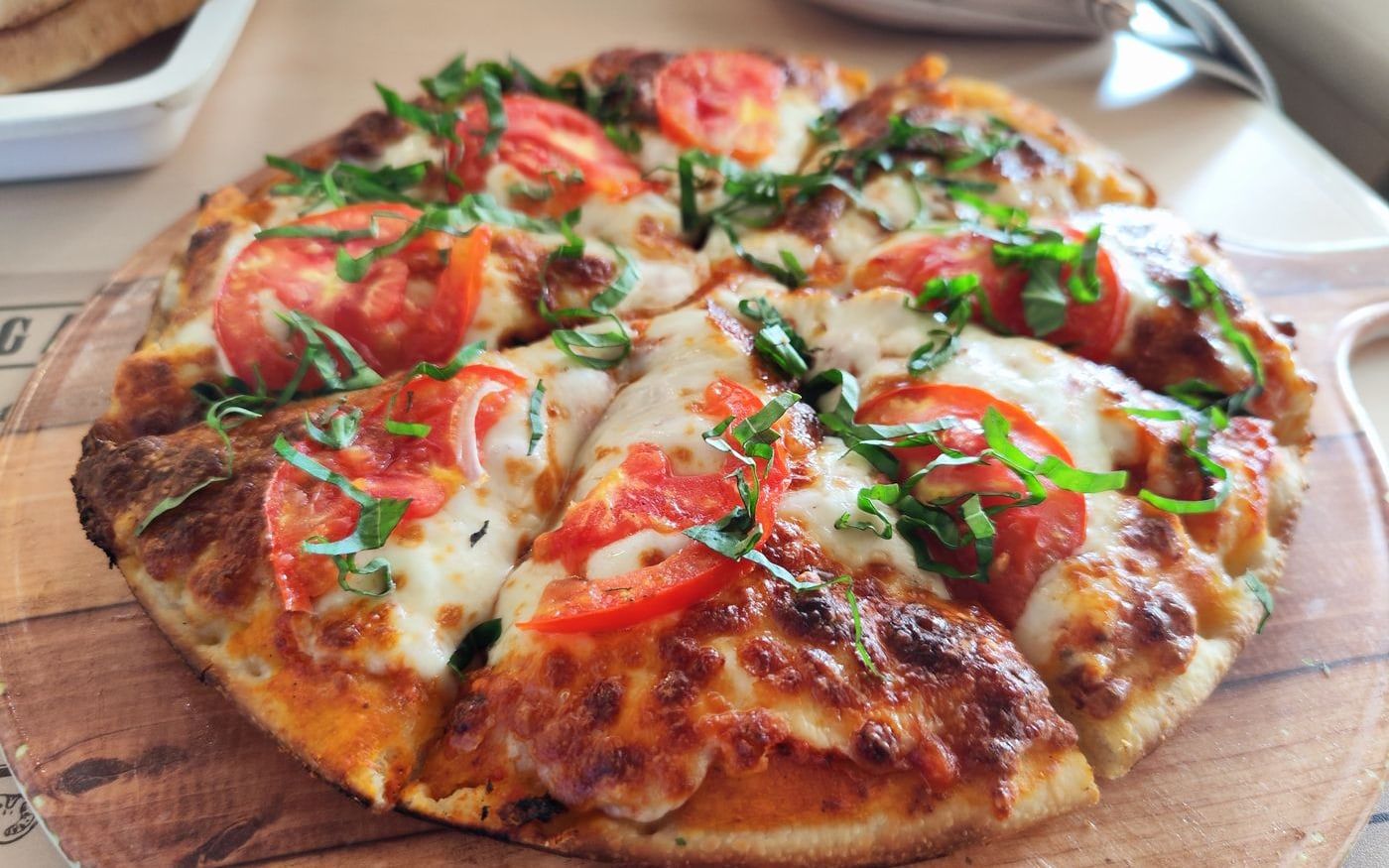 A pizza cut into slices on a wooden board